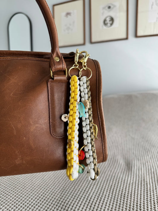 yellow and white paracord charm, with bone fish charm and bone beads
